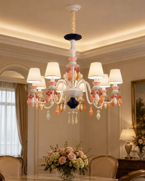 Belle Époque 10-light chandelier with ivory pleated shades, white sculptural arms and pastel hanging ornaments in a formal dining room.
