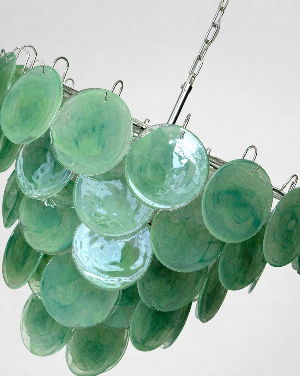 Close-up of layered handmade emerald-green glass discs on the chandelier.