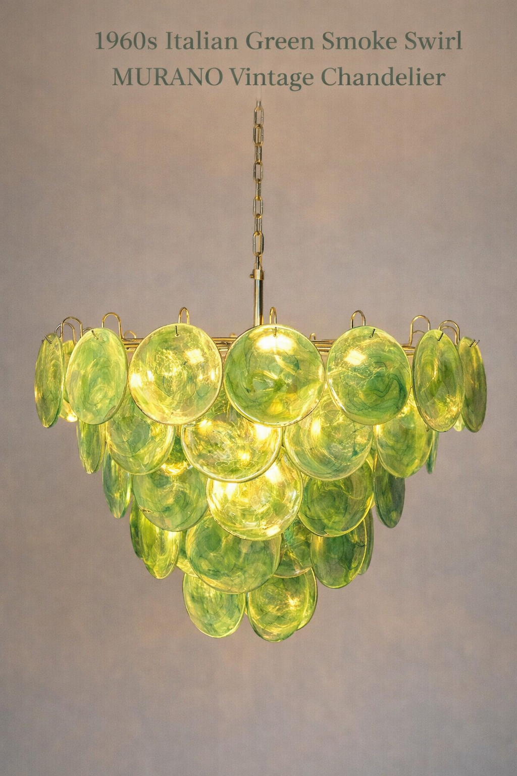 Emerald disc-glass chandelier illuminated with warm-white light.