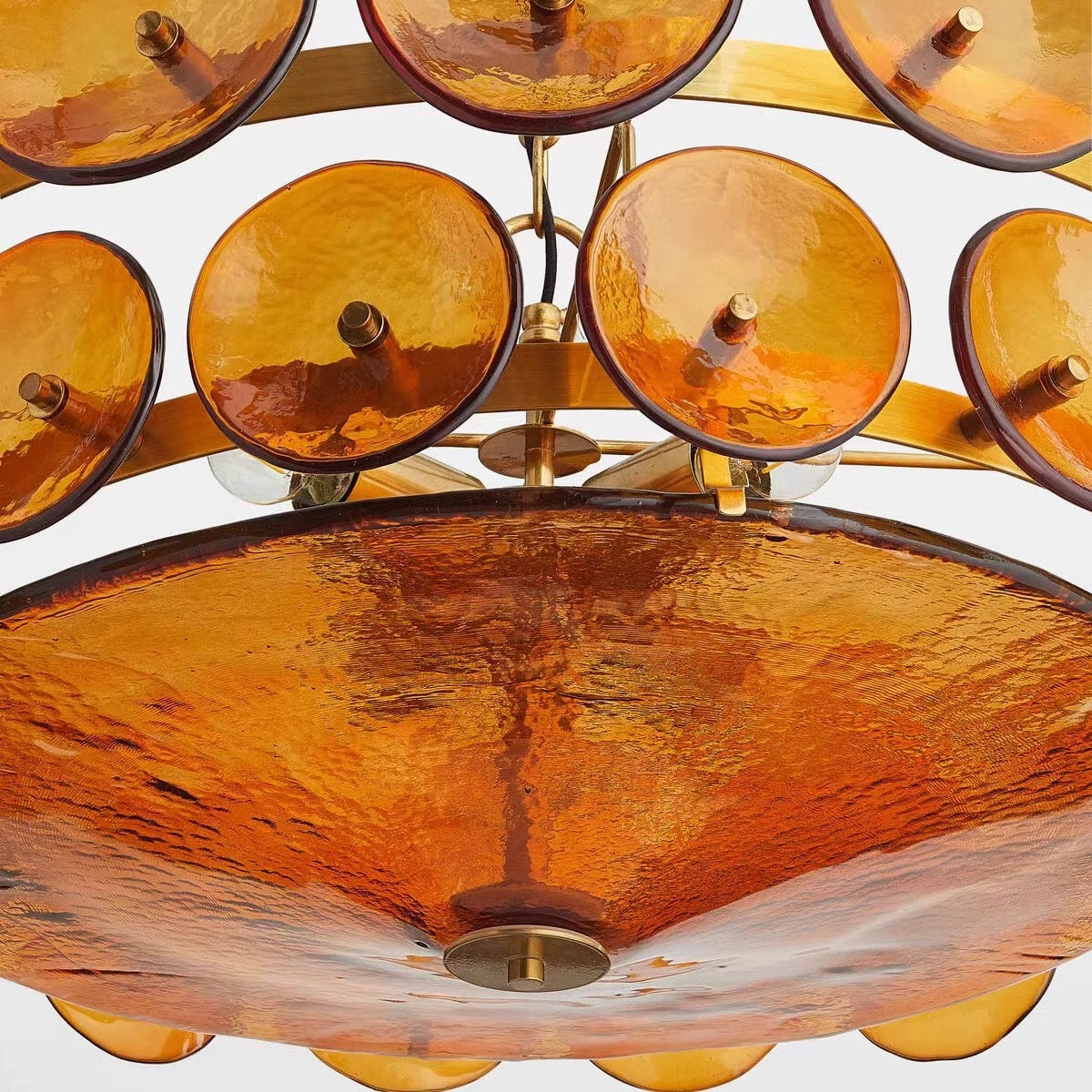 Close-up of the amber glass lower bowl and surrounding textured discs.