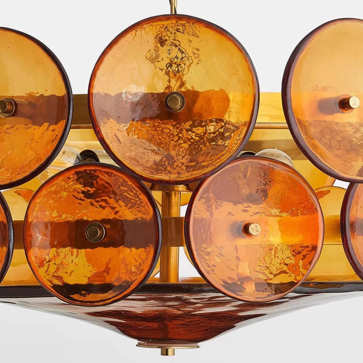 Close-up of the tea-brown textured glass discs and warm metal frame.