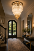 Tiered clear glass tube flush-mount chandelier glowing in a traditional entry hall.