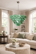 Emerald-green disc glass cascade chandelier above a neutral contemporary living room.